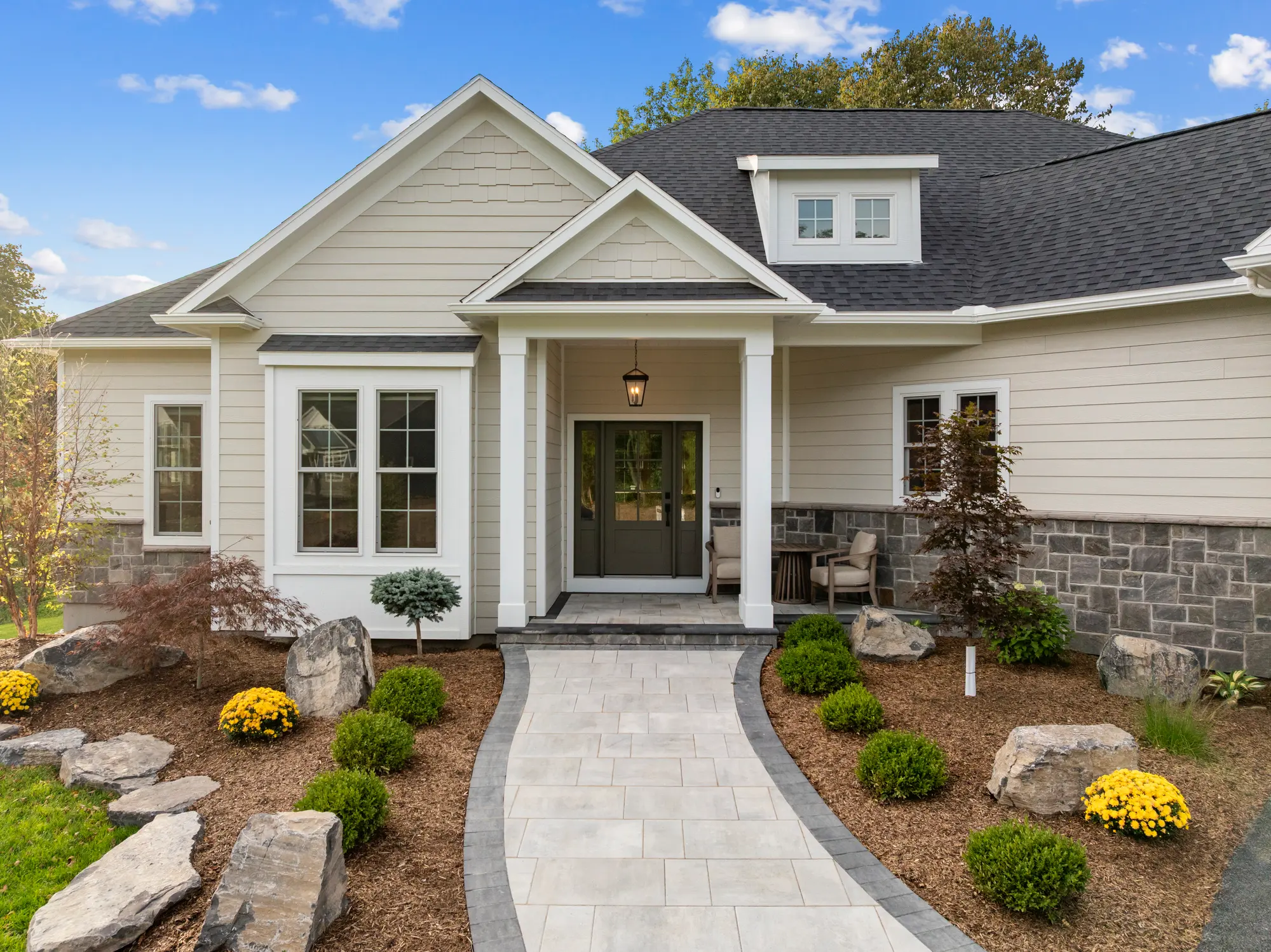 The Cabot Ridge by Mark Antony Homes, front exterior with a stone-accented porch and a landscaped paver walkway