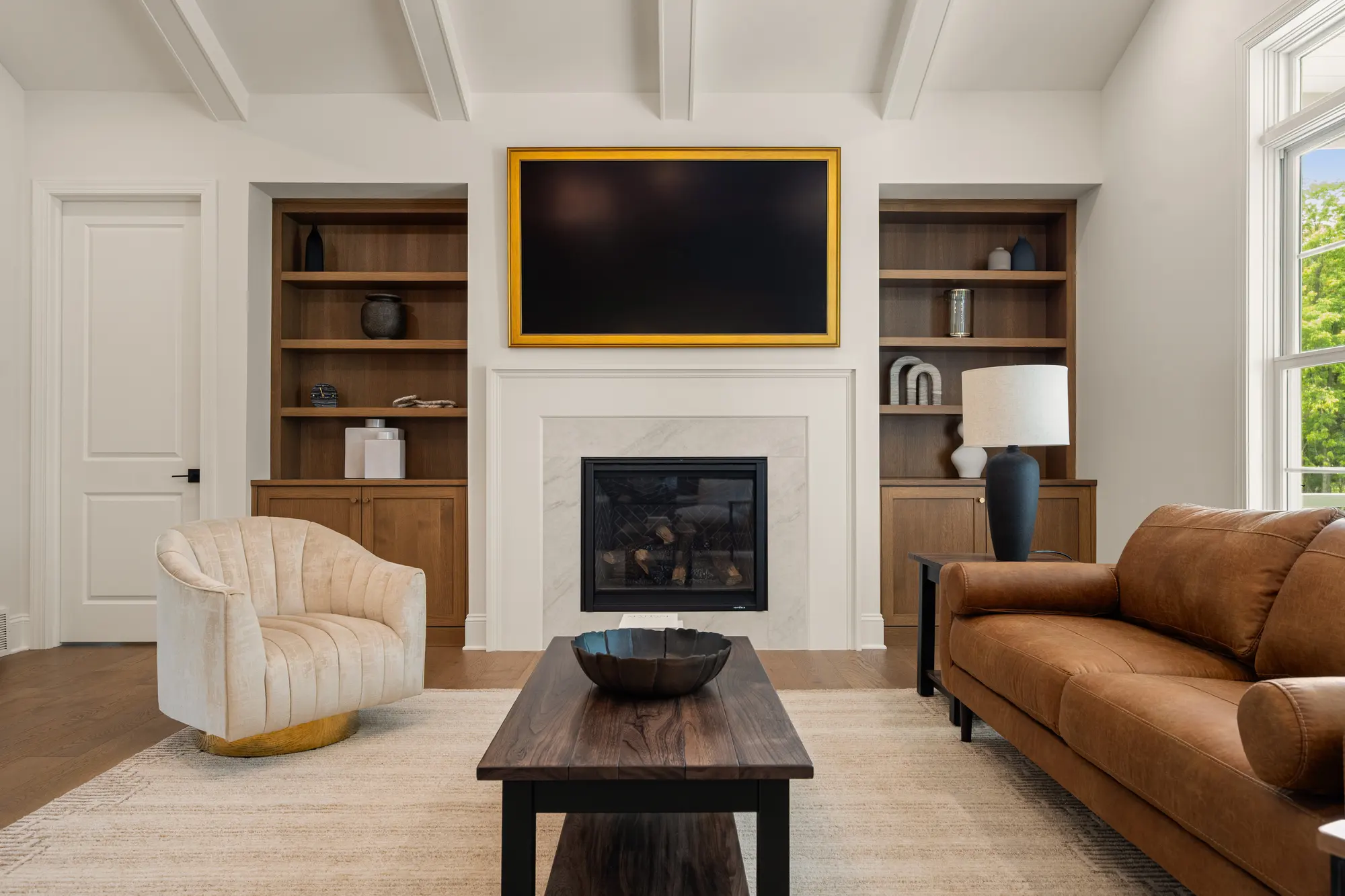 Great room in The Cabot Ridge with a beamed ceiling, fireplace and built-in shelving